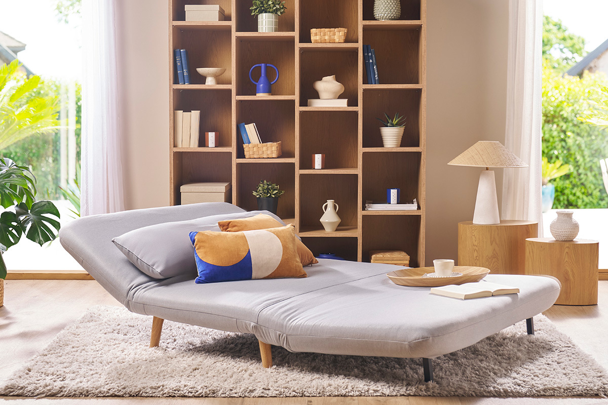 Banquette convertible 2 places AMIKO en tissu gris clair, vue de face avec coussins color�s.