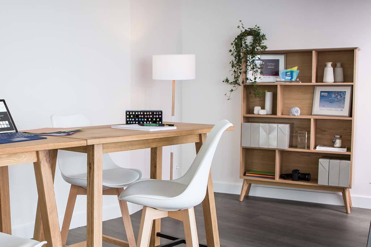 Biblioth�que scandinave en bois clair avec 8 casiers, entour�e d'autres meubles.