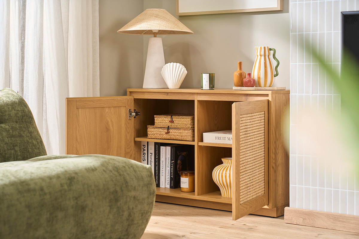 Buffet bas en bois clair ch�ne avec portes en cannage rotin, vue de profil avec d�corations.