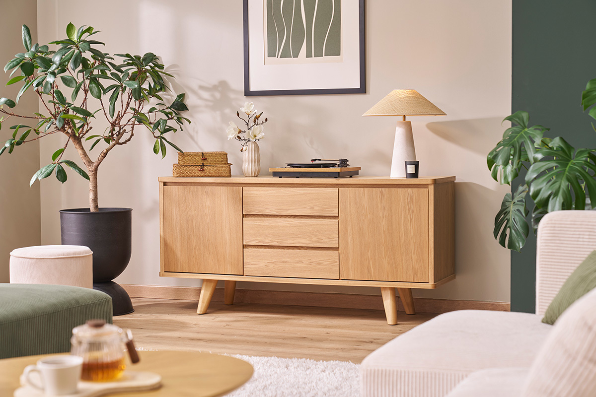 Buffet scandinave en bois clair, 2 portes, 3 tiroirs, plantes et lampe d�coratives.