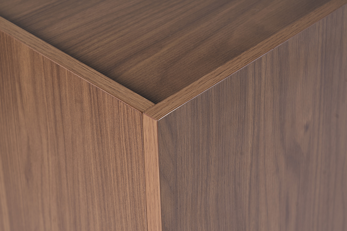 Coin d'un buffet en bois finition noyer brun, vue rapproch�e du grain et des veines.
