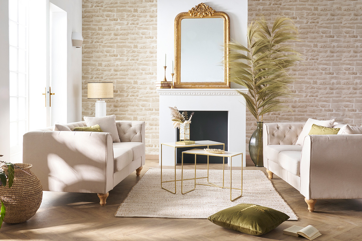 Deux canap�s 2 places en tissu beige dans un salon lumineux avec tables et d�coration.