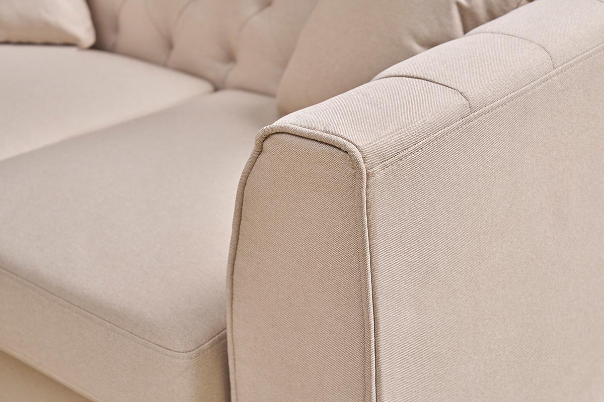 Gros plan sur accoudoir du canap� 2 places MONTAIGNE en tissu beige avec capitonnage.