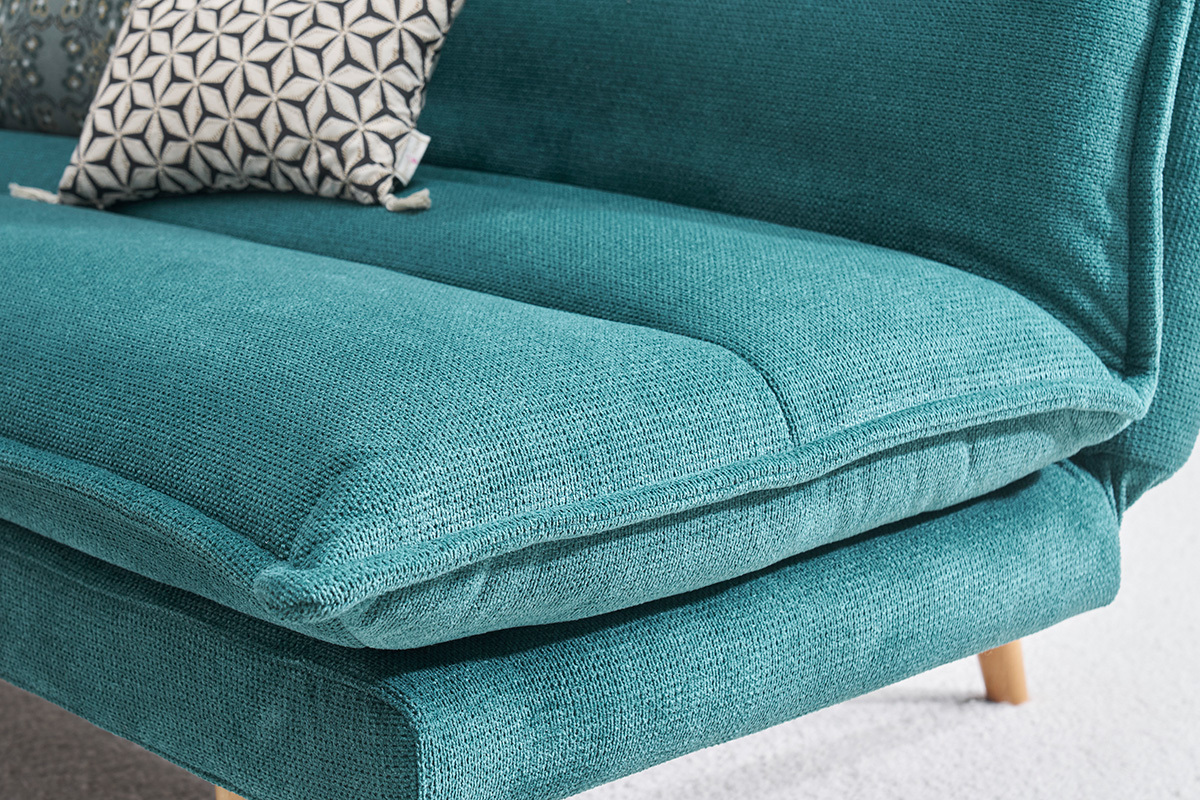 Canap� convertible bleu canard en tissu chenille avec coussin g�om�trique, vue en gros plan.