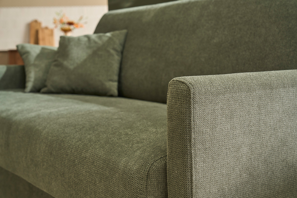 Gros plan sur le canap� convertible SKANDY en tissu chenille vert fonc� avec coussins.