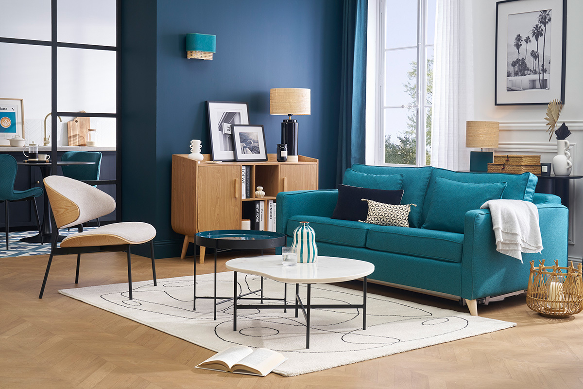 Canap� convertible bleu canard 3 places avec tables basses modernes en salon.