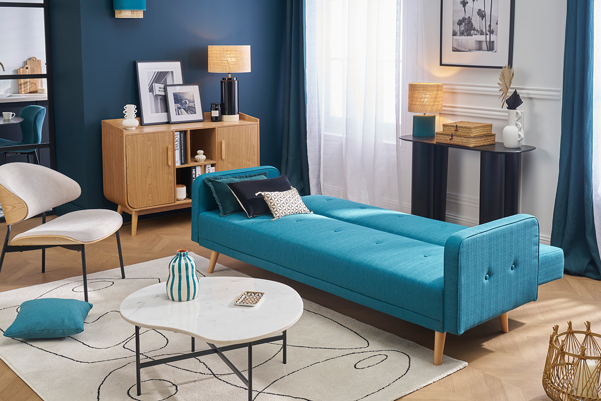 Canap� convertible scandinave bleu et bois clair en mode lit dans un salon moderne.