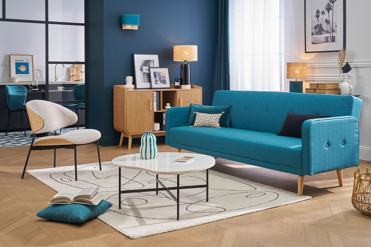 Canap� convertible scandinave bleu � trois places dans un salon moderne.