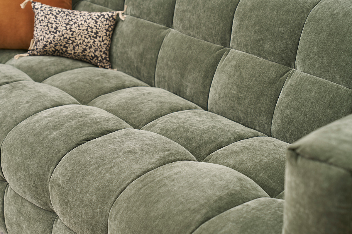 D�tail du canap� d'angle gauche CORTO en tissu velours vert kaki avec coussin d�coratif.