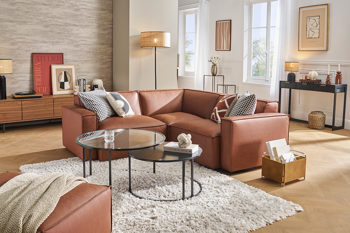 Canap� d'angle en cuir marron dans un salon moderne avec table basse et tapis.