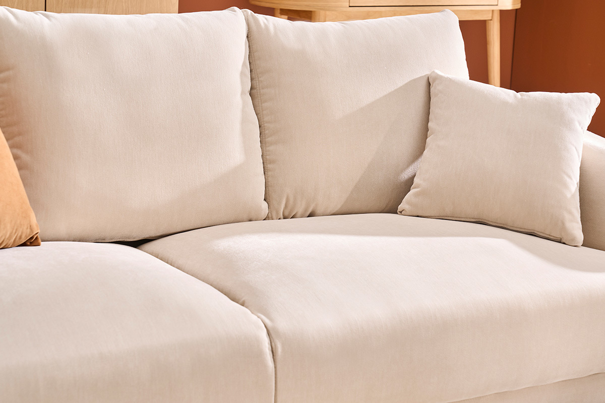 Canap� beige en tissu effet velours, vue partielle des coussins et assise.