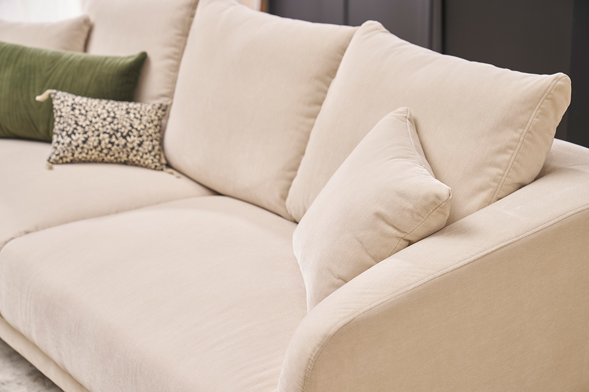 Canap� 3 places en tissu velours beige avec coussins, vue lat�rale.