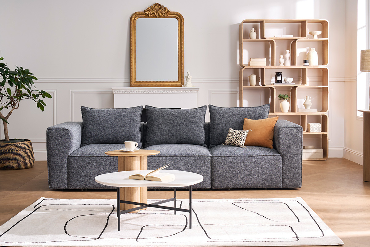 Canap� modulable KERRY 4 places en tissu gris avec coussins, table basse et tapis dans un salon contemporain.