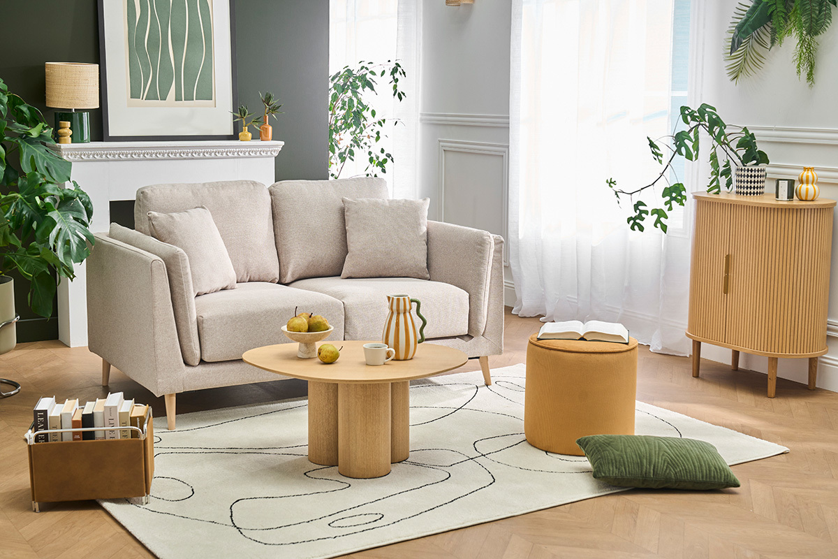Canap� scandinave 2 places beige avec coussins, table et accessoires d�co dans un salon lumineux.
