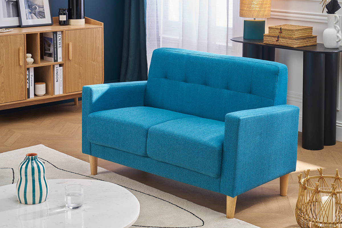 Canap� scandinave 2 places bleu canard en tissu et bois clair, vue d'angle dans un salon.