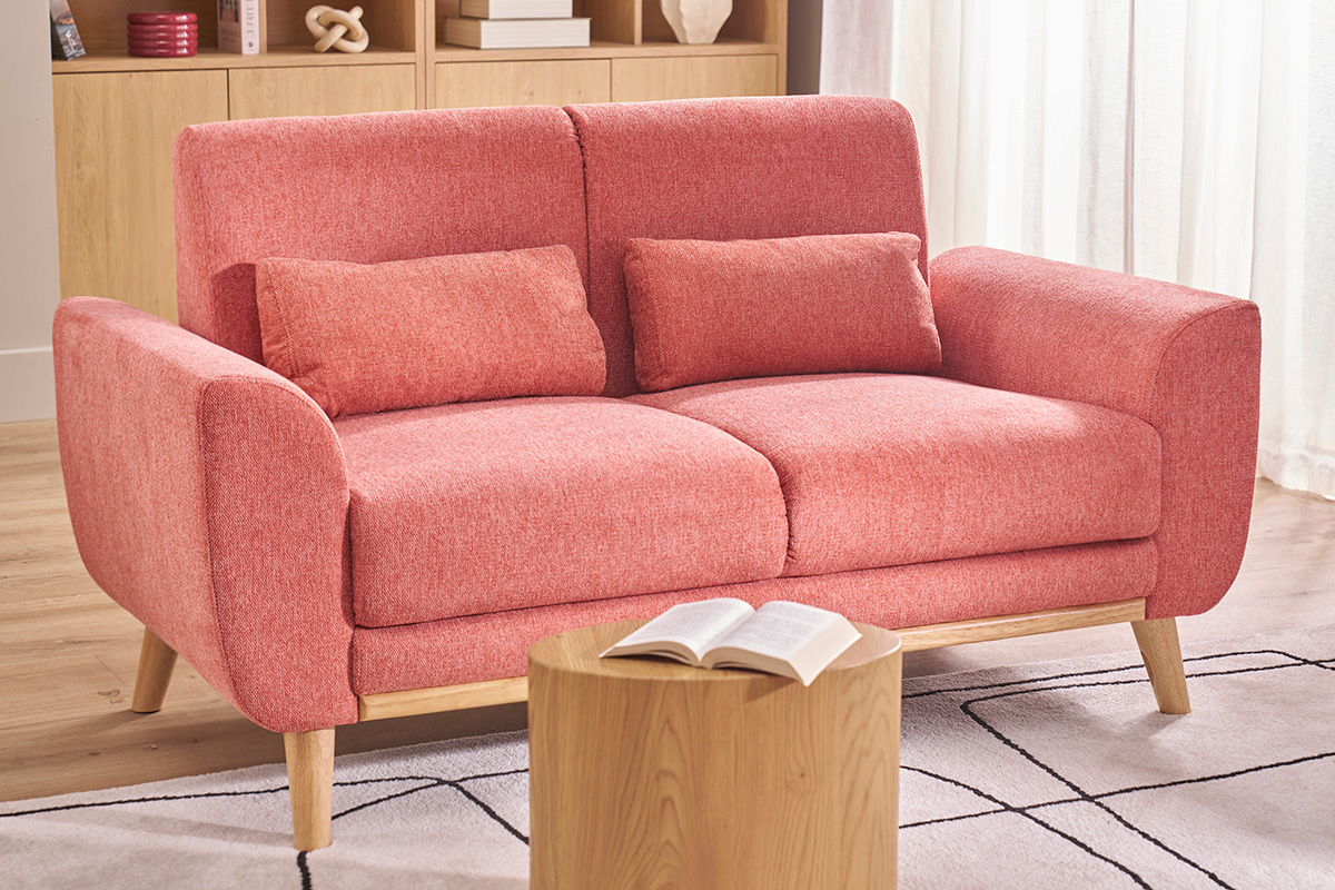Canap� scandinave terracotta 2 places avec coussins, pieds en bois clair, table basse devant.