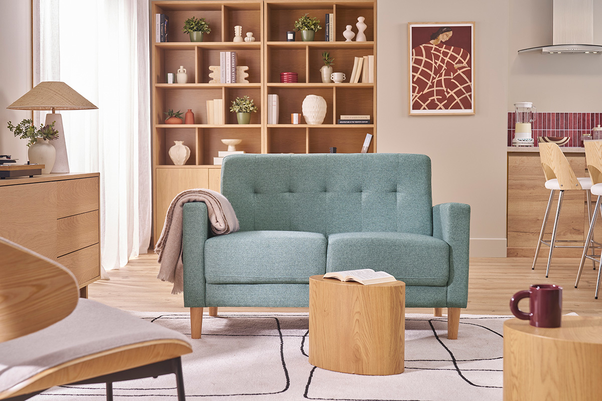 Canap� scandinave 2 places vert de gris avec dossier capitonn�, dans un salon.