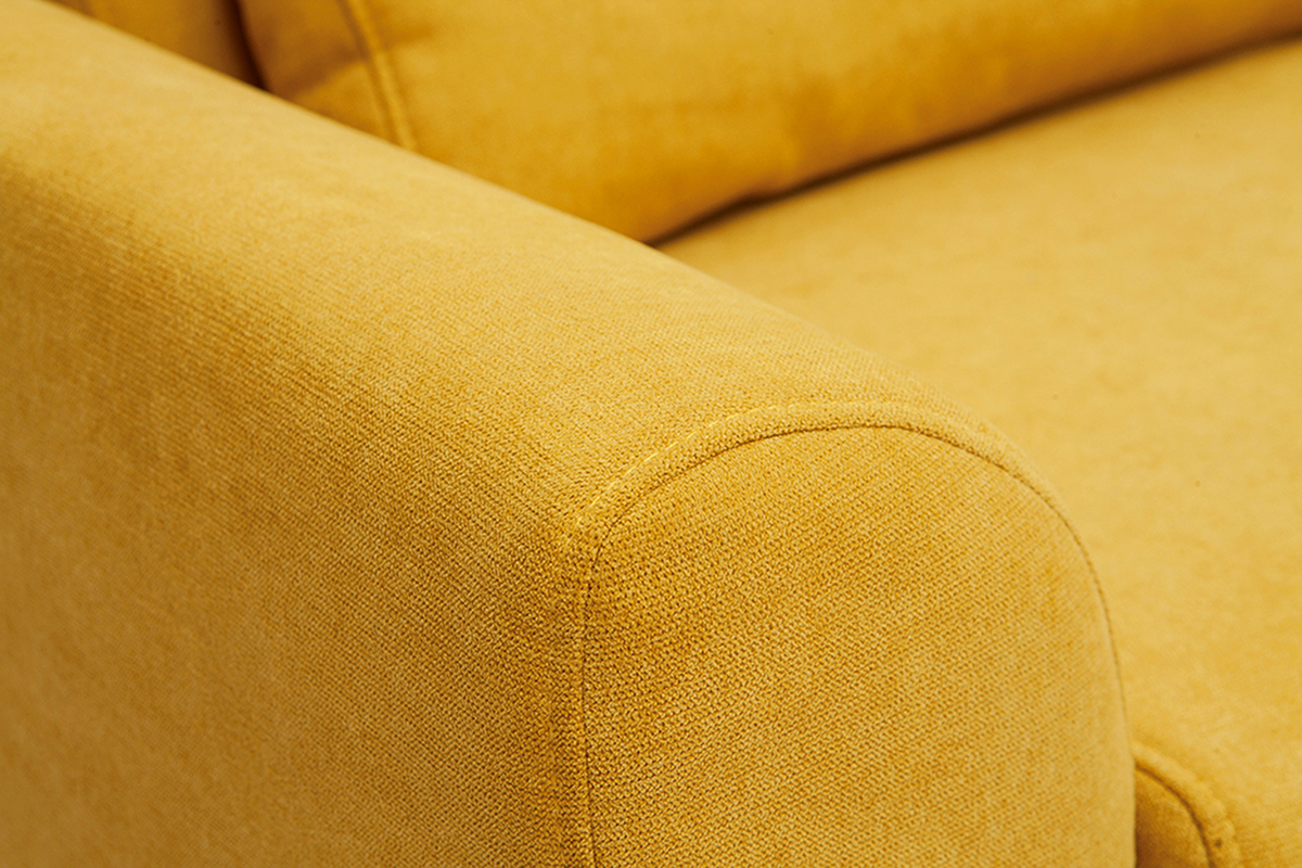 D�tail d'un canap� scandinave 3 places en tissu velours jaune moutarde, vue rapproch�e du dossier et de l'accoudoir.