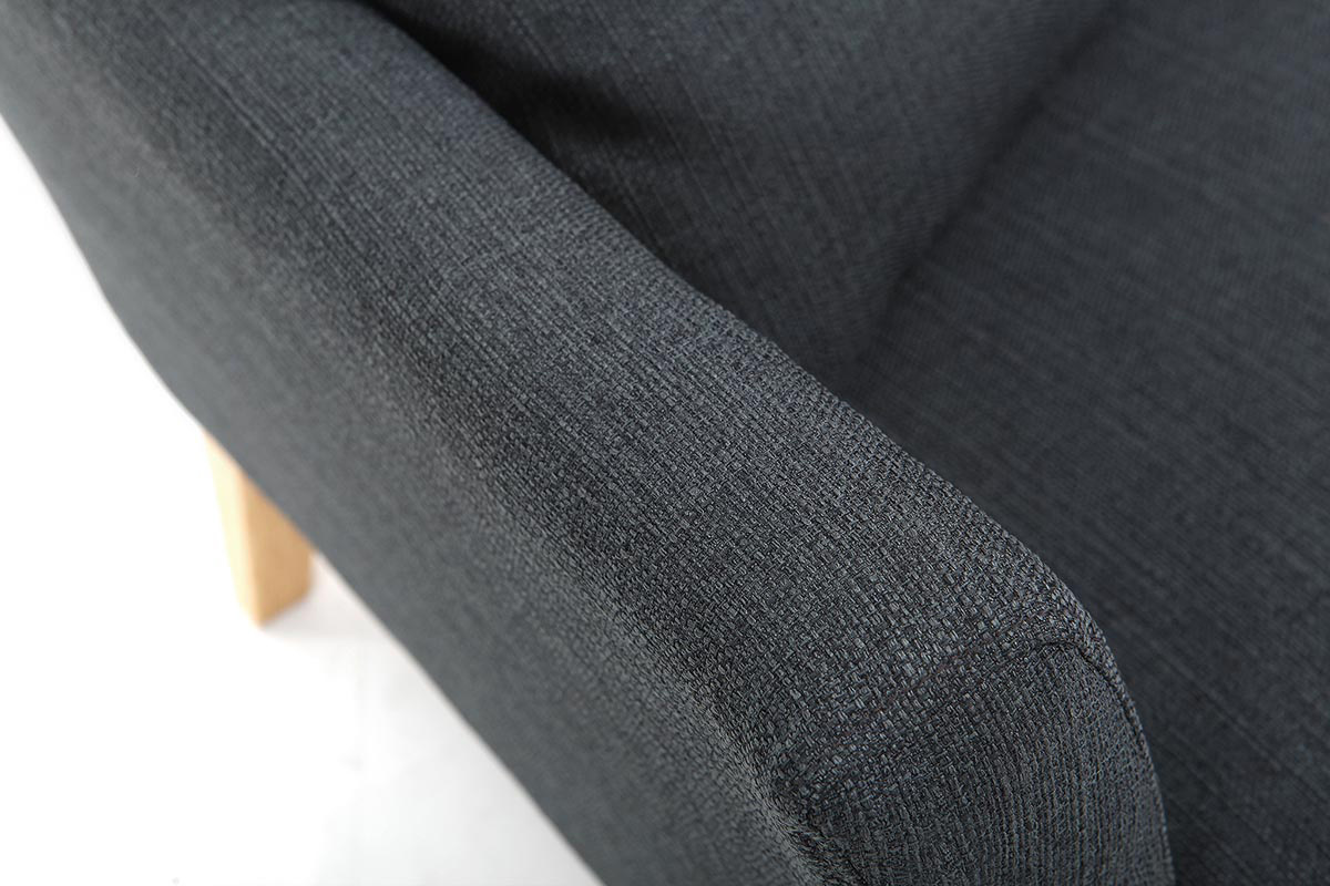 Accoudoir du canap� OSLO en tissu gris fonc� avec pied en bois clair, vue en gros plan.