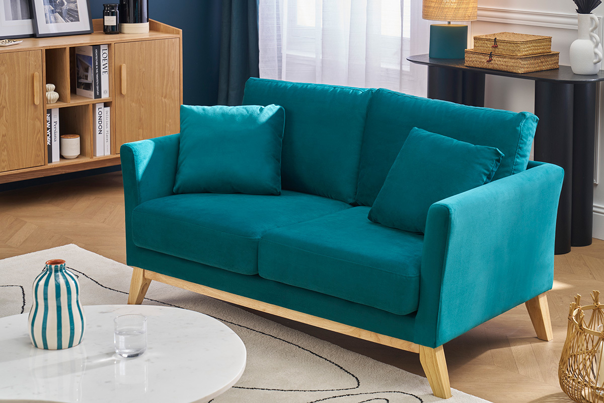Canap� scandinave 2 places en velours bleu p�trole et bois clair dans un salon moderne.