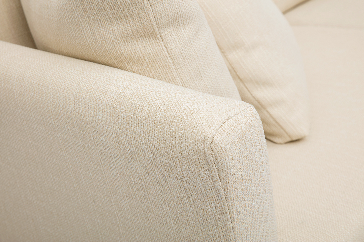 Gros plan d'un canap� scandinave beige en tissu avec accoudoir et coussin.