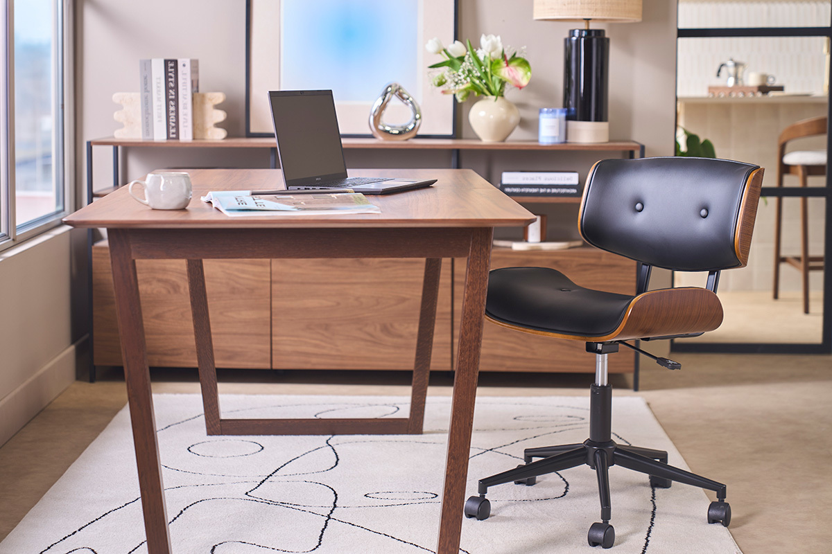 Chaise de bureau � roulettes noire et bois fonc� BASILE devant un bureau, vue de 3/4