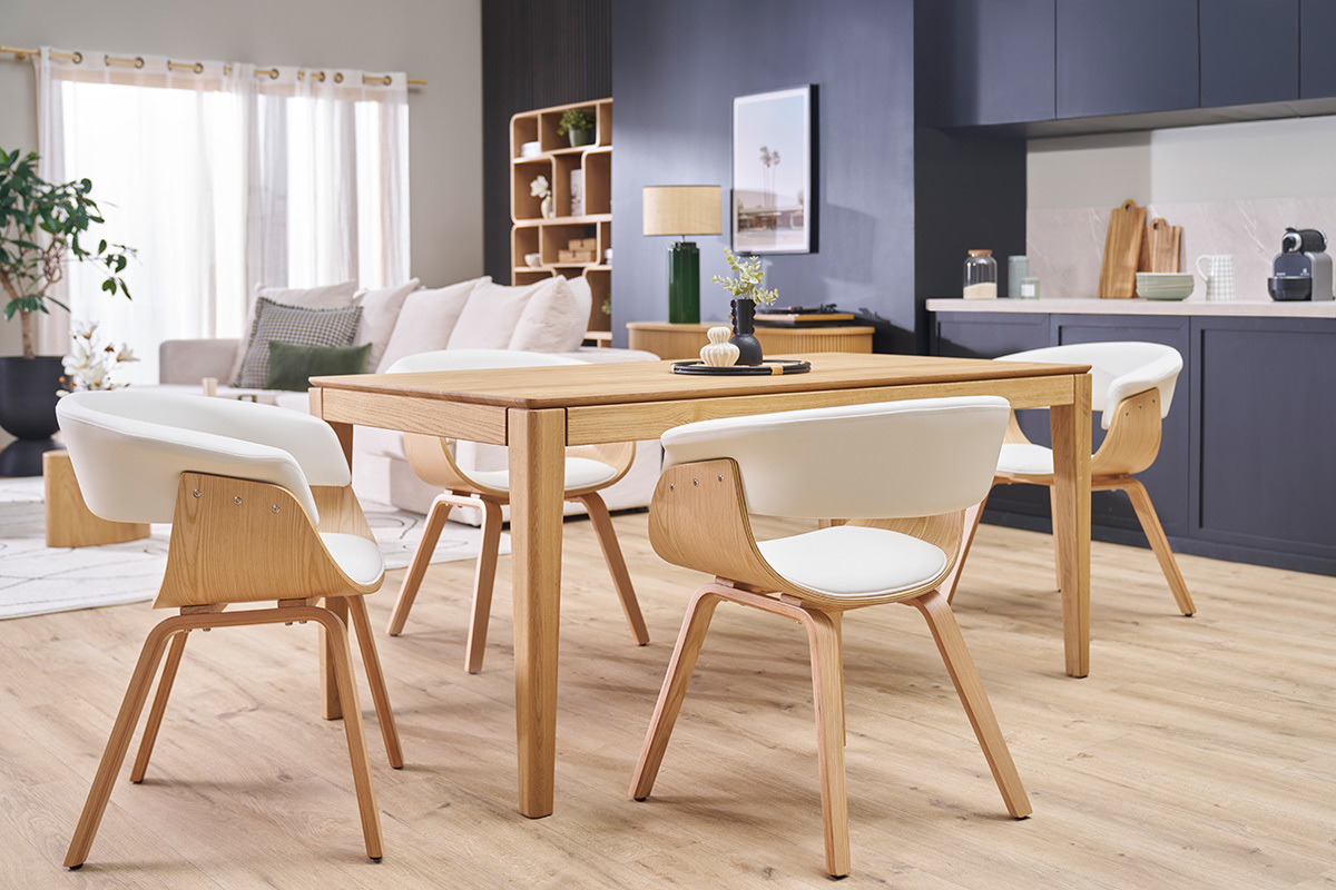 Salle � manger avec chaises scandinaves blanches et bois clair autour d'une table en bois.