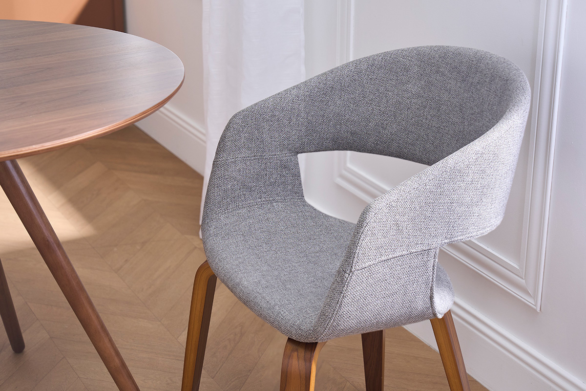 Chaise design en tissu gris avec pieds en bois fonc�, vue de pr�s.