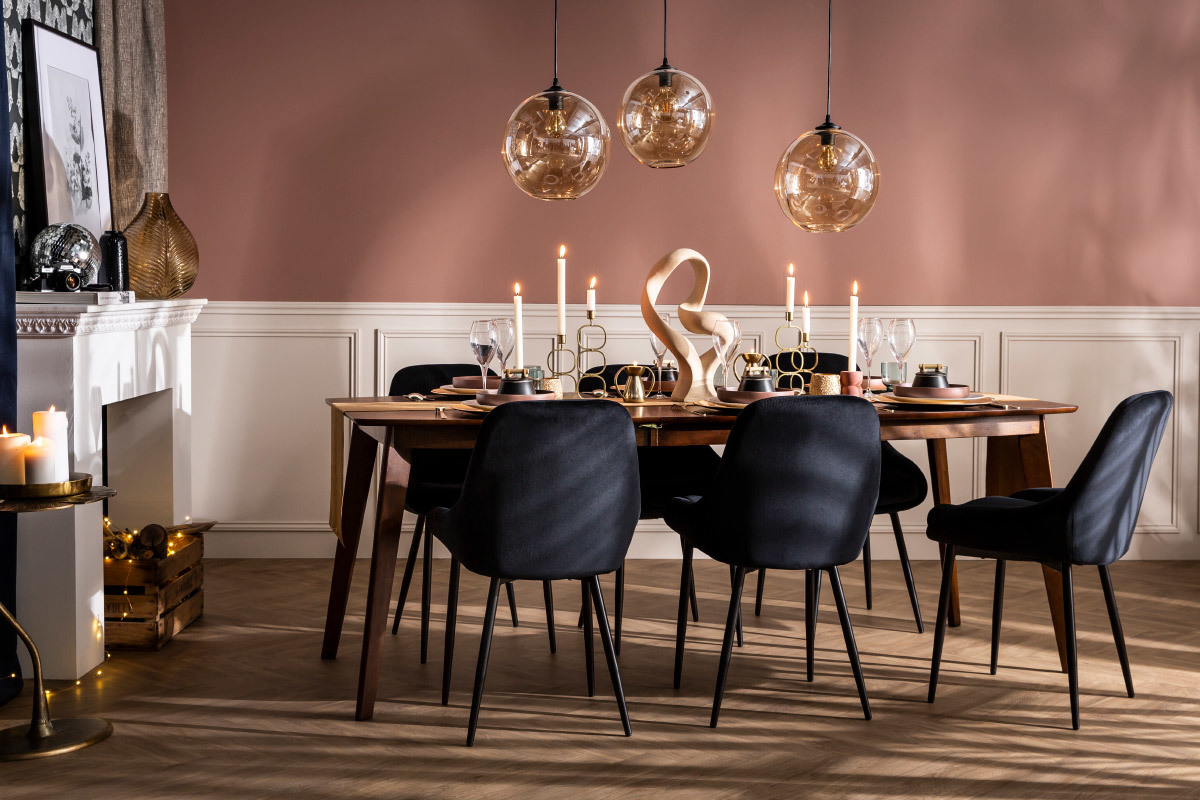 Salle � manger avec chaises noires en velours et m�tal autour d'une table en bois.