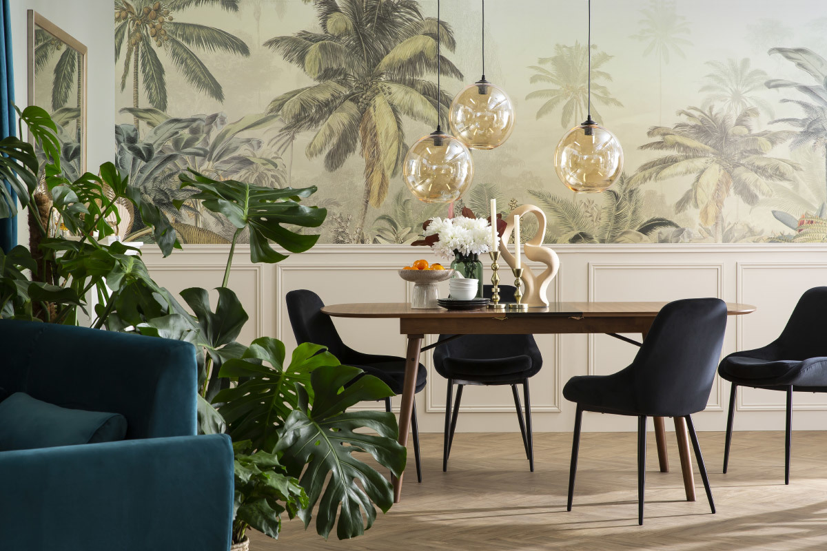 Salle � manger avec chaises noires en velours et m�tal autour d'une table en bois, d�cor tropical.