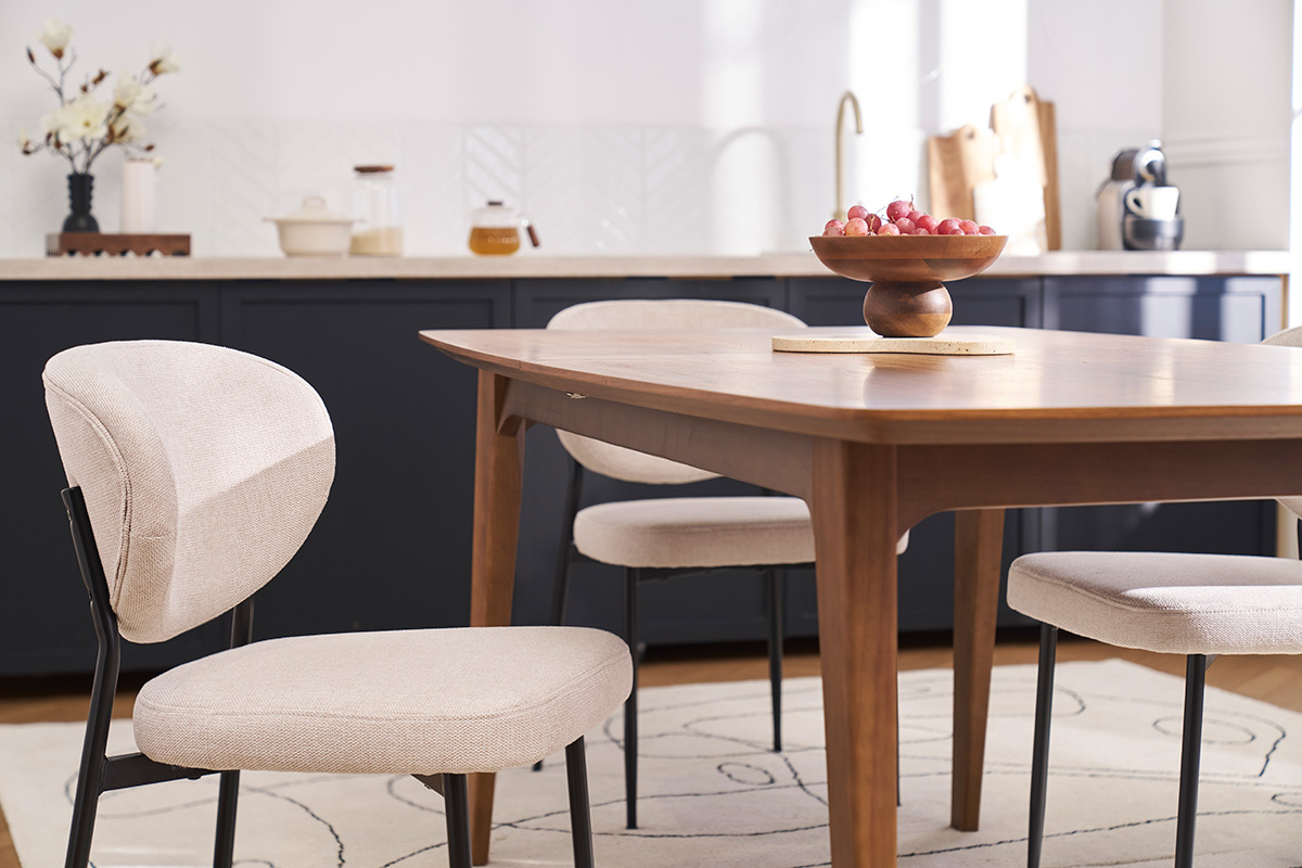 Chaises BREKA beige en tissu effet velours avec pieds en m�tal noir autour d'une table en bois.