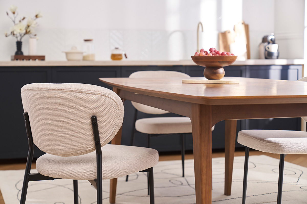 Chaises BREKA en tissu effet velours beige autour d'une table en bois dans une salle � manger moderne.