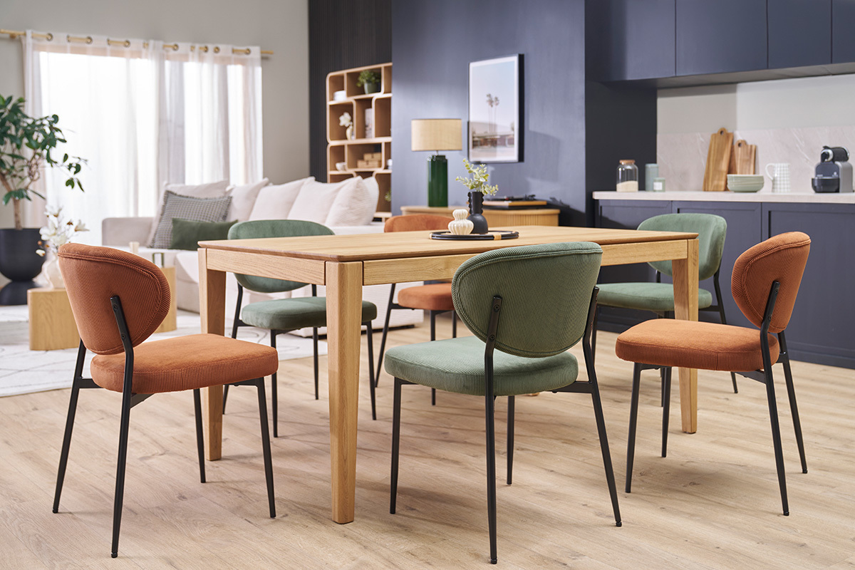 Chaises en velours c�tel� terre br�l�e et m�tal noir autour d'une table en bois, vue int�rieure.