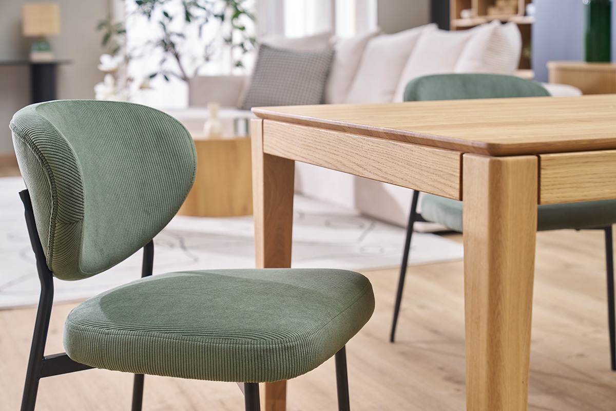 Chaises en velours vert kaki et m�tal noir autour d'une table en bois, int�rieur moderne.