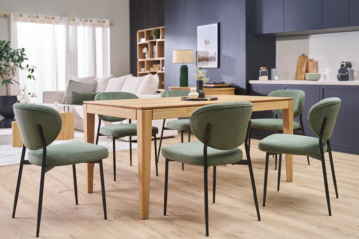 Chaises en velours c�tel� vert kaki et m�tal noir autour d'une table en bois dans une salle � manger.