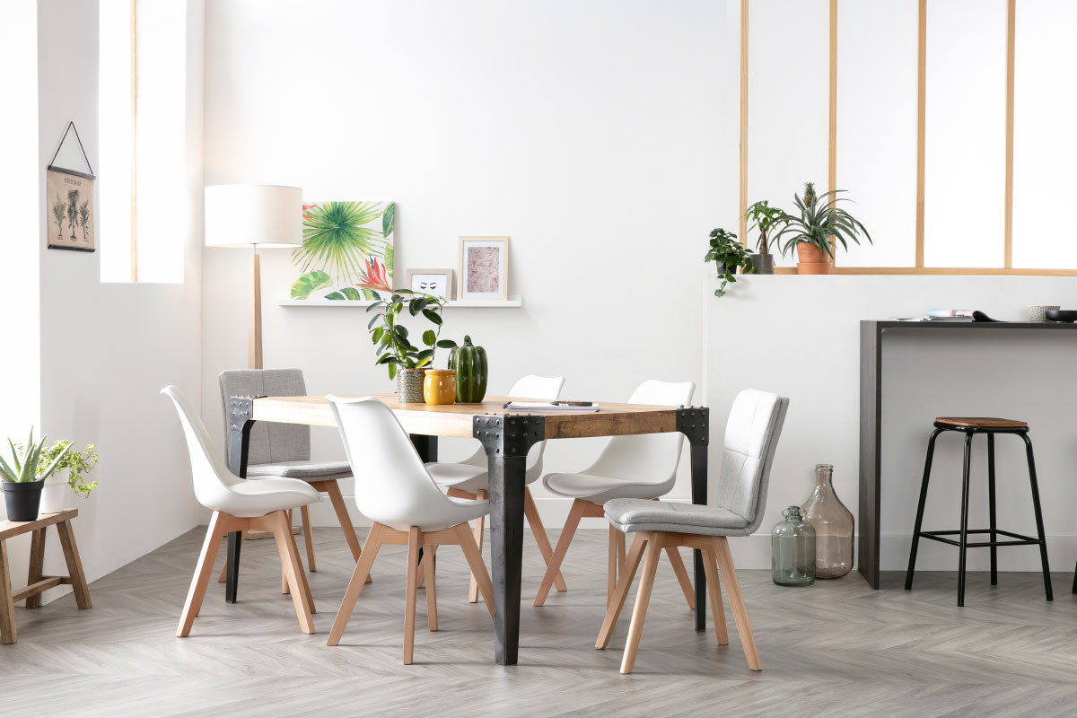 Chaises scandinaves blanches et table en bois clair dans une salle � manger moderne.