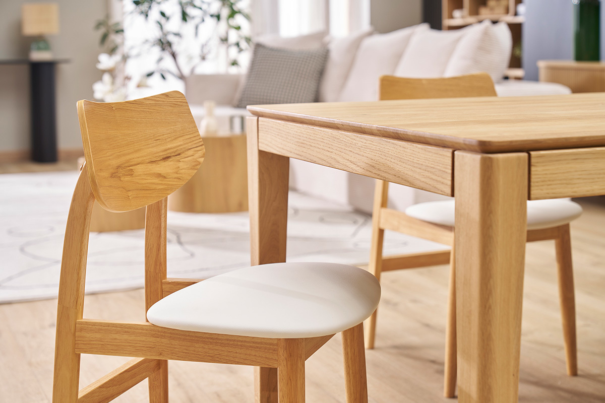 Chaises scandinaves en bois clair avec assise blanche, autour d'une table en bois, int�rieur moderne.