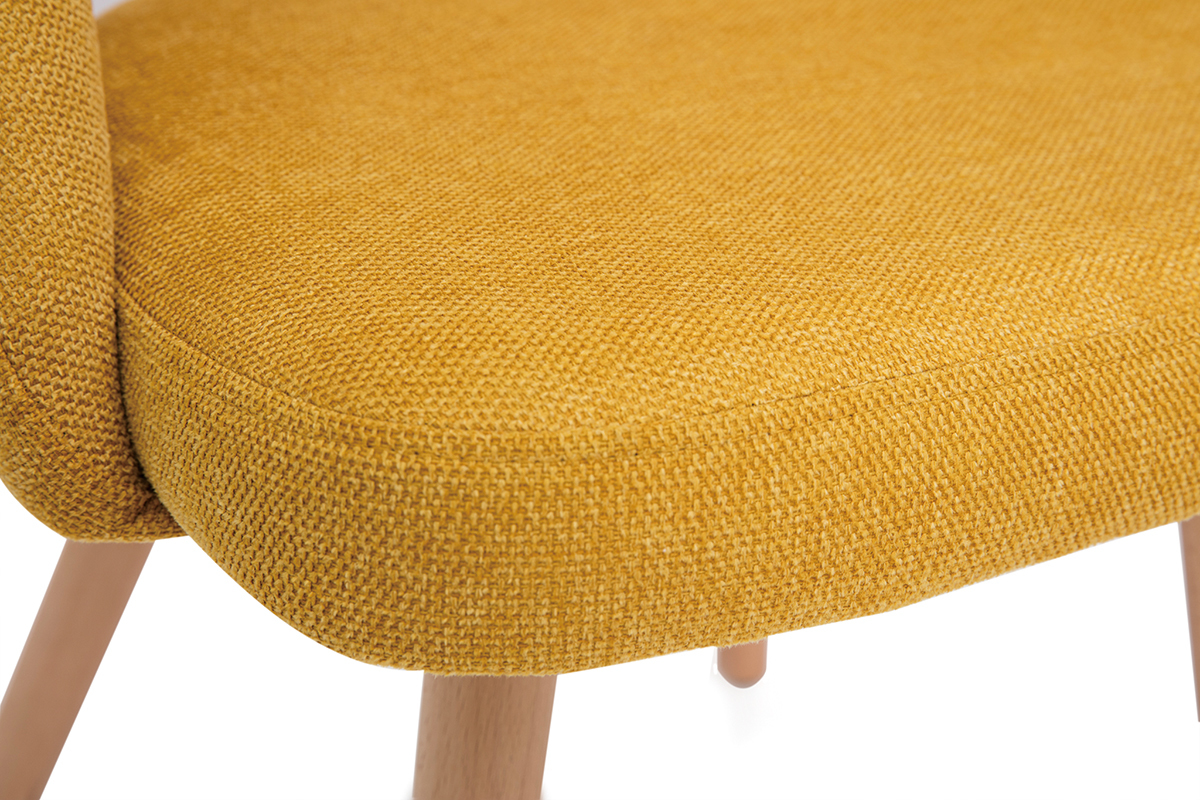 Gros plan sur une chaise scandinave en tissu velours jaune moutarde et pieds en bois clair.