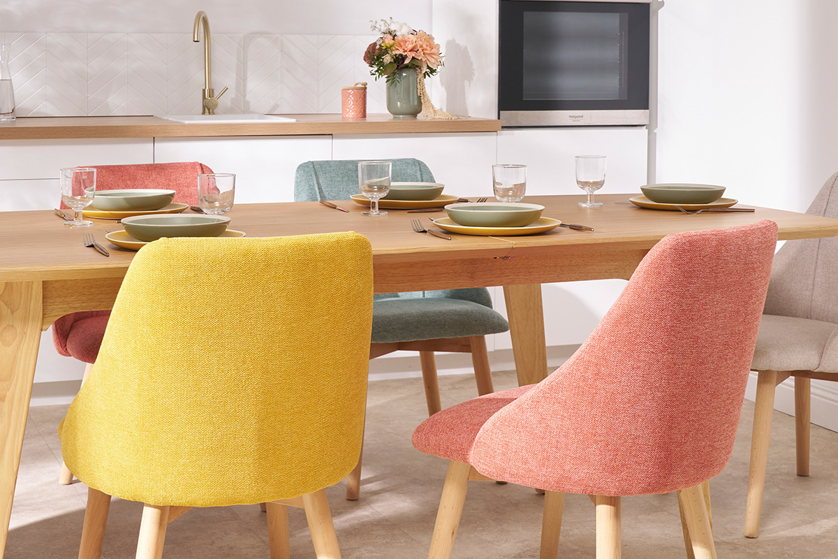 Groupe de chaises scandinaves en tissu terracotta autour d'une table en bois clair.