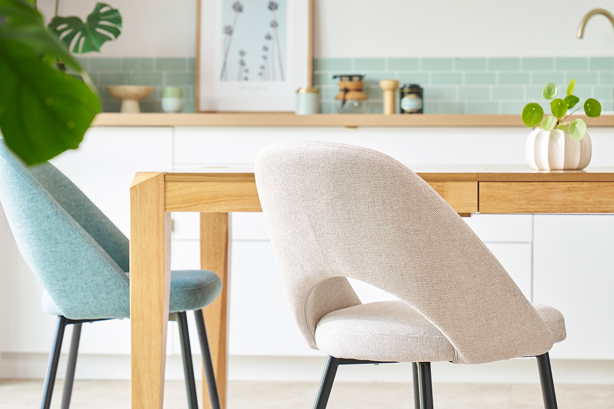 Chaises beige en tissu effet velours avec dossier haut courb�, pieds en m�tal noir, dans une salle � manger.