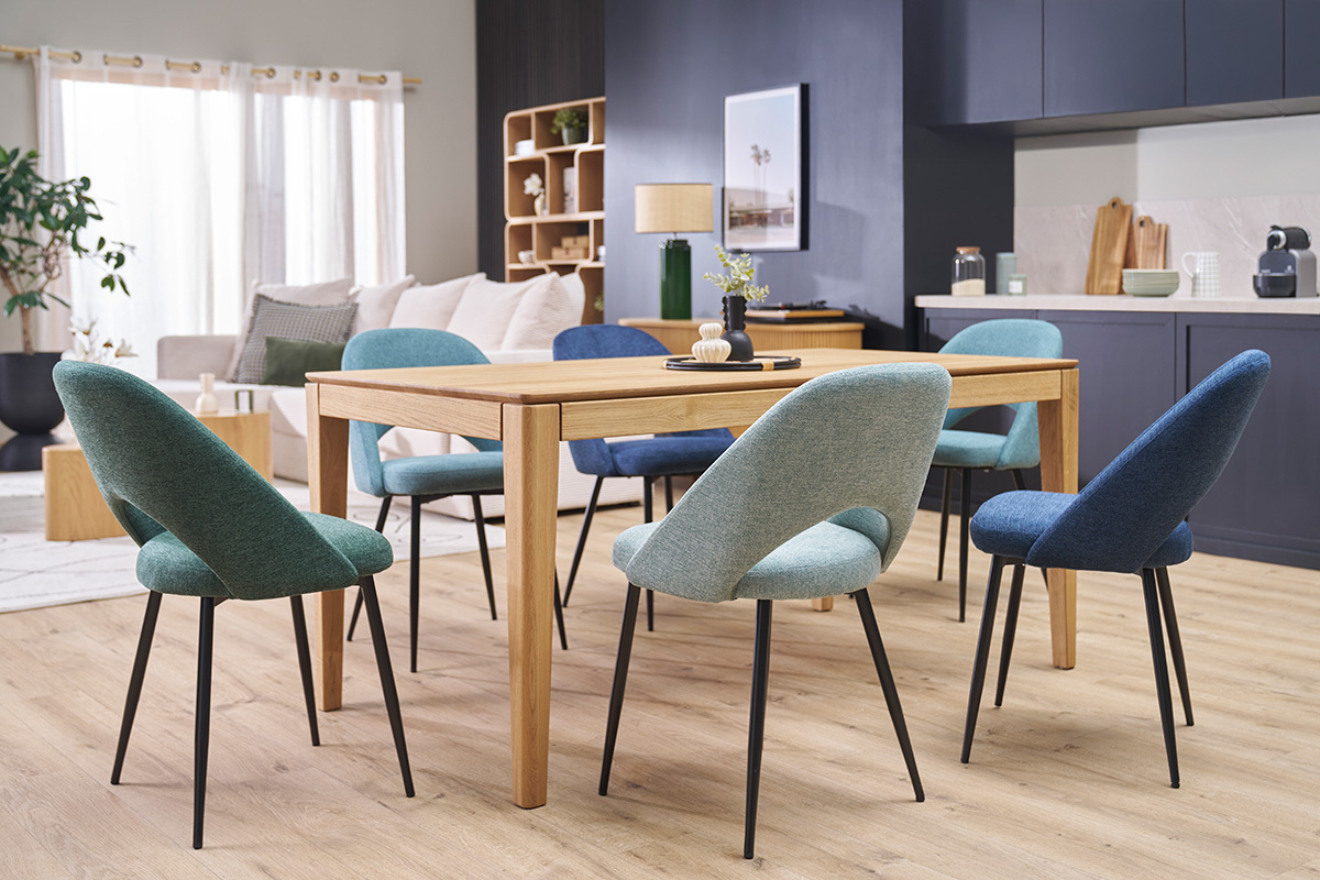 Chaises vert c�ladon en tissu velours et pieds m�talliques noirs autour d'une table en bois, vue int�rieure.