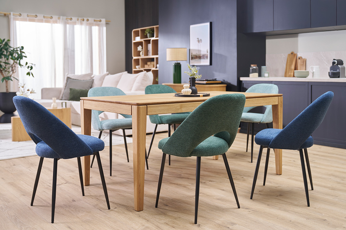 Chaises vintage vertes et bleues autour d'une table en bois dans une salle � manger moderne.