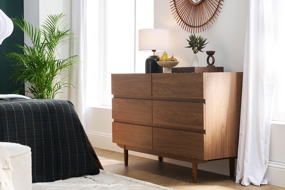 Commode SANAA en bois fonc� avec 6 tiroirs, vue de c�t� dans une chambre d�cor�e.