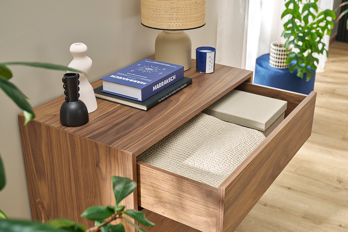 Commode en bois fonc� avec tiroir ouvert, lampes et livres sur le dessus.