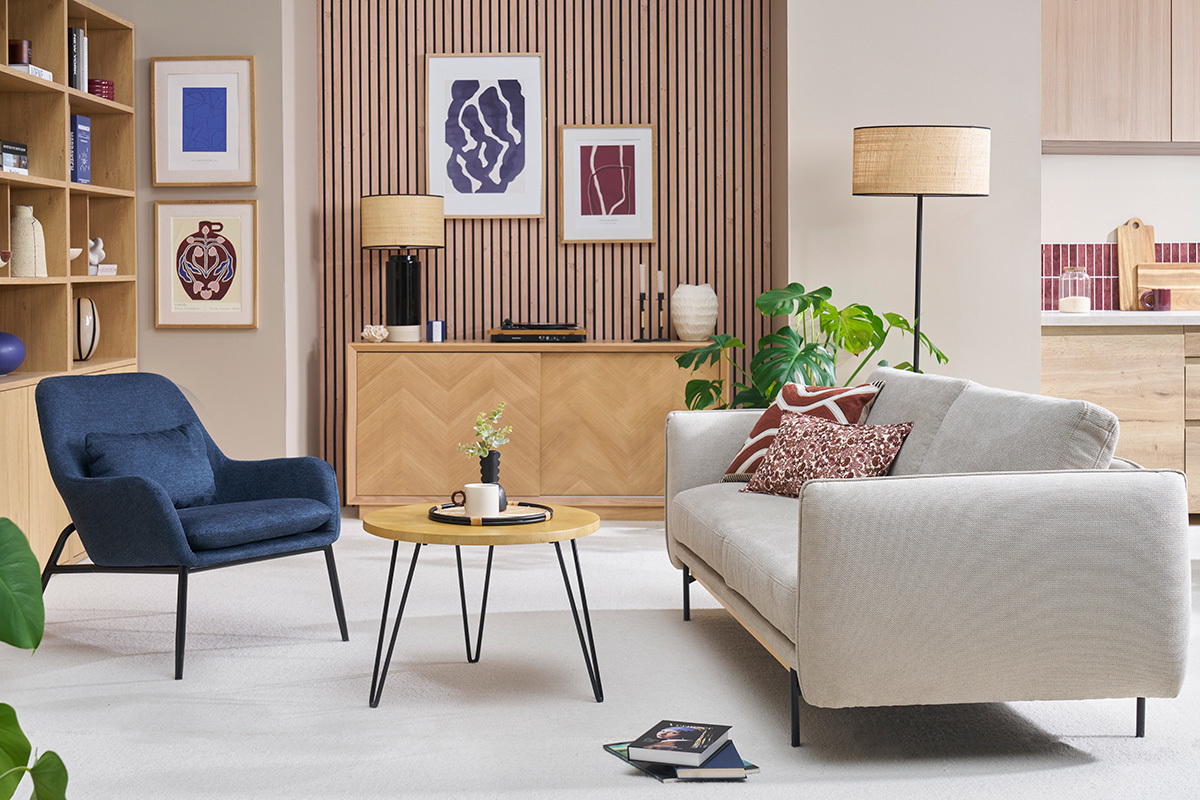 Fauteuil bleu fonc� en tissu effet velours avec pieds en m�tal noir, dans un salon moderne.