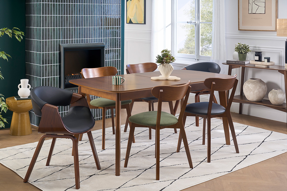 Fauteuil design noir ARAMIS en position assise dans une salle � manger moderne avec d'autres chaises.