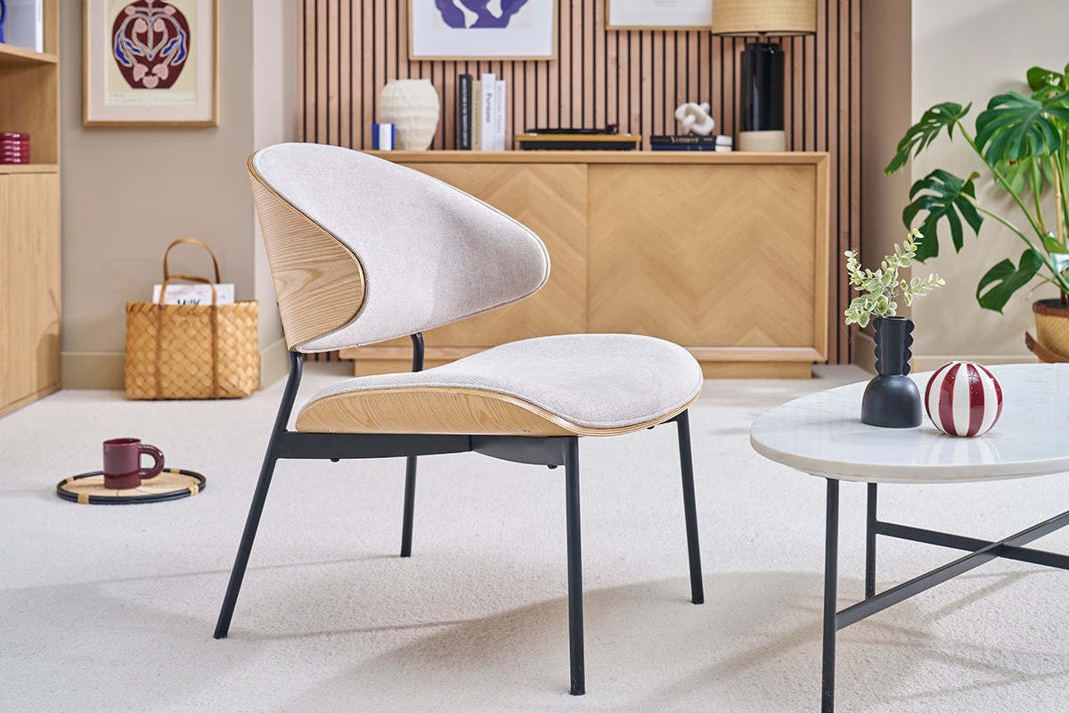 Fauteuil beige en tissu effet velours, bois clair et m�tal noir dans un salon moderne.