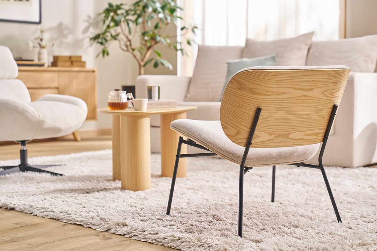 Fauteuil SHELBY beige en tissu et m�tal noir, dos en bois vu de c�t� dans un salon moderne.