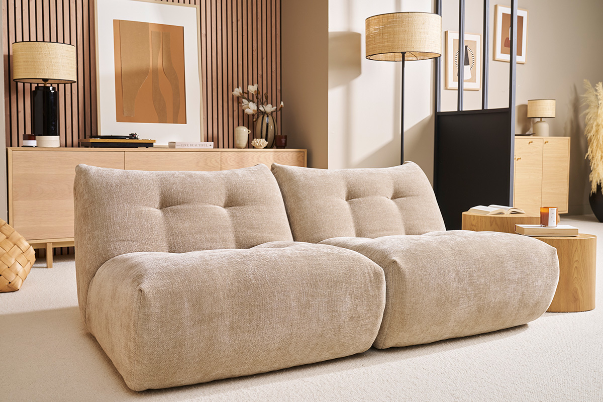 Fauteuil lounge en tissu effet velours taupe dans un salon moderne.