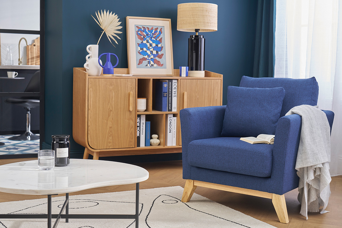 Fauteuil scandinave bleu fonc� et bois clair dans un salon moderne.